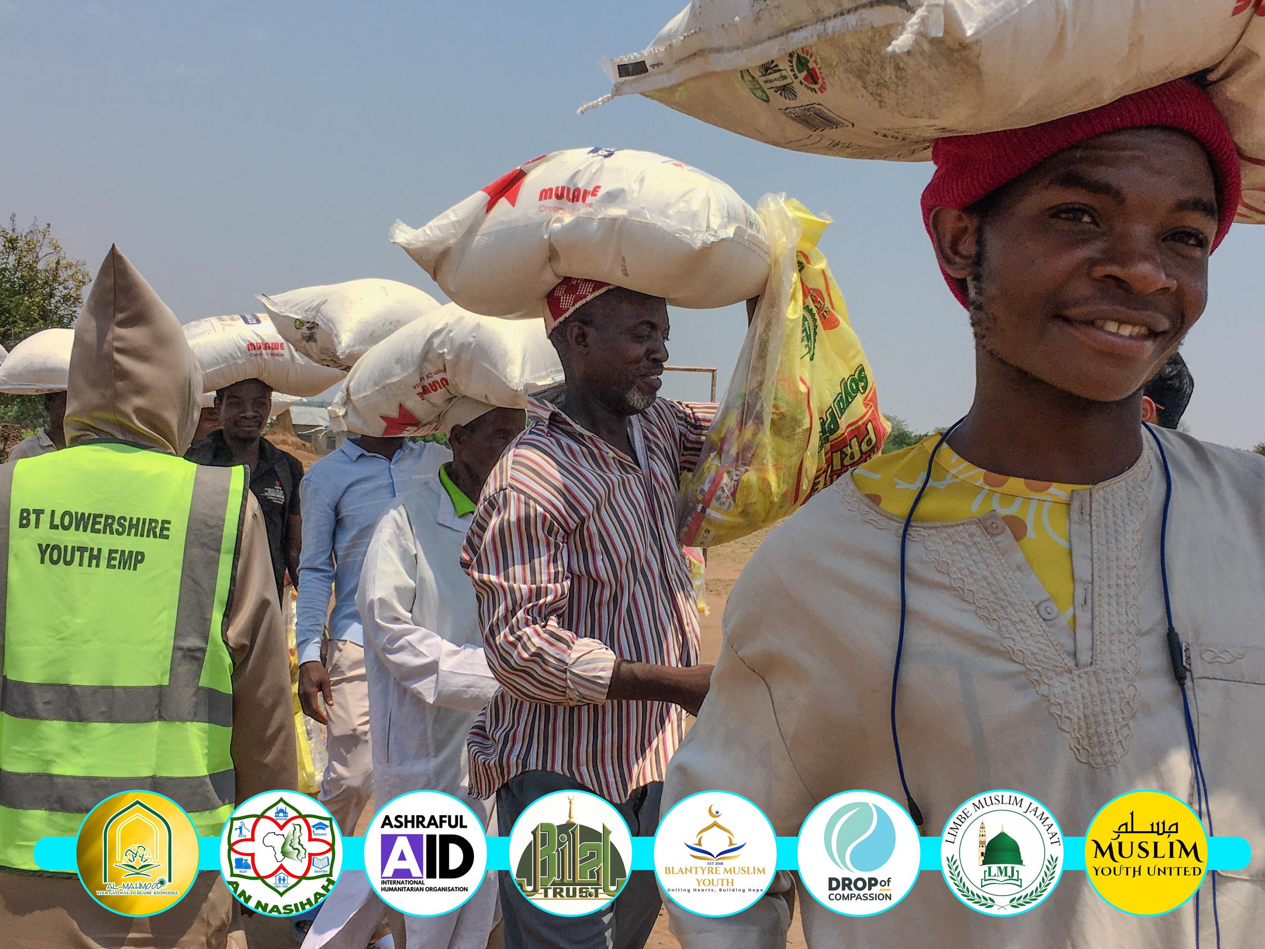 Distribution team hands over food packs to families.